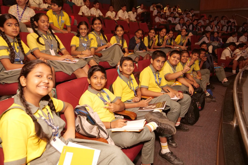 Students sitting in the summit audience with notebooks